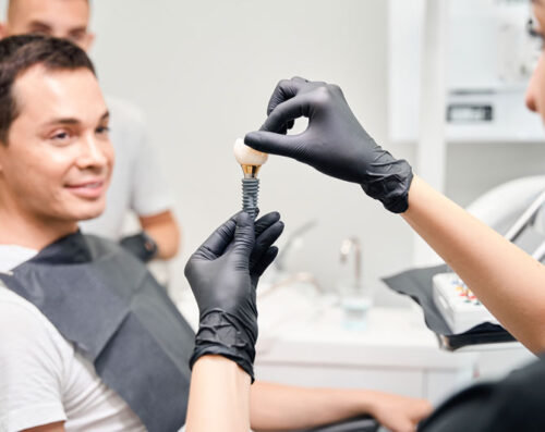 Aesthetic stomatology client watching at process of dental implant installation.